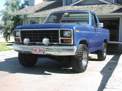 1981 Ford Bronco - This 1981 Ford Bronco features a lifted suspension, aggressive off-road tires, and a custom 'FIRE DEPT' license plate.