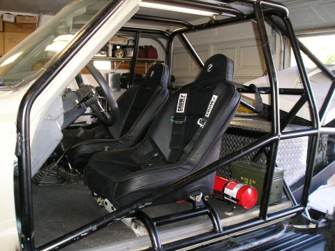 1986 Toyota Hilux - This vehicle's interior has been modified with racing seats and a full roll cage for off-road use.