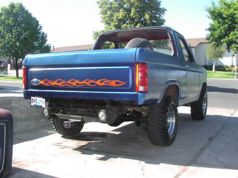 1981 Ford Bronco - Blue Ford Bronco with flame decals, seen from the rear. The year is estimated based on body style.