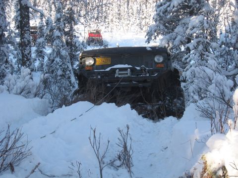 1990 Ford F-250 - This vehicle is navigating a snowy trail with another vehicle visible in the background.
