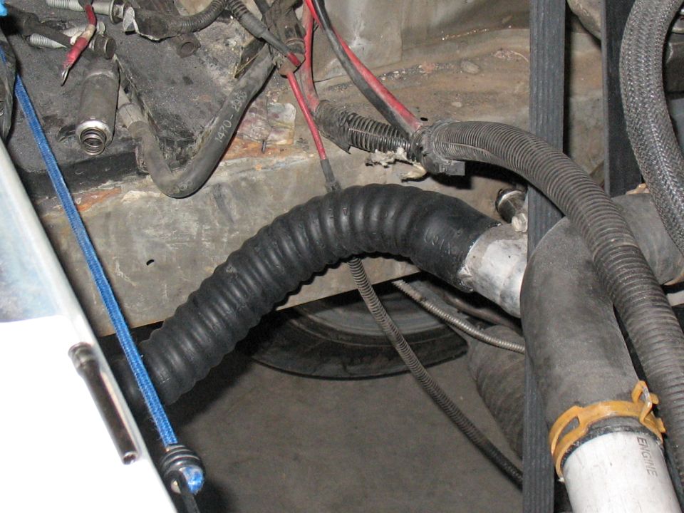 Close-up of engine bay with black hoses and red and black wires