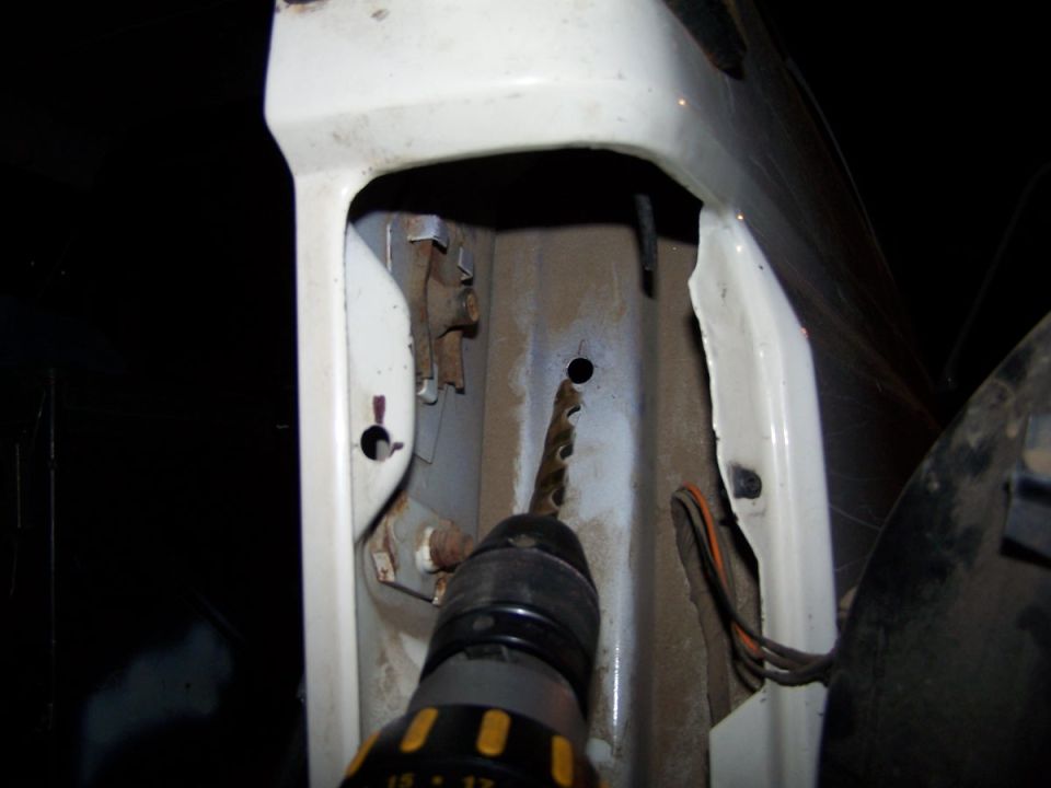 Drilling a hole in the white body of a vehicle, near some wires