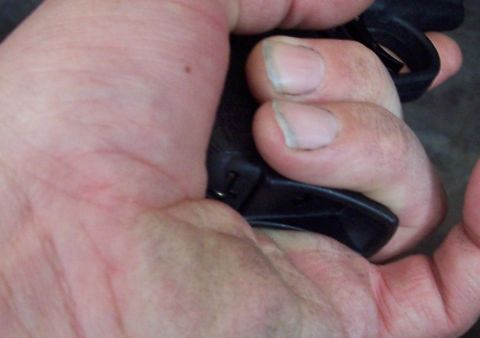 1990 Ford Bronco - Close-up of a hand holding a black object, with fingers and thumb visible.