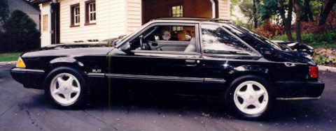 1988 Ford Mustang - Side view of a black 1988 Ford Mustang LX 5.0 coupe with a spoiler.