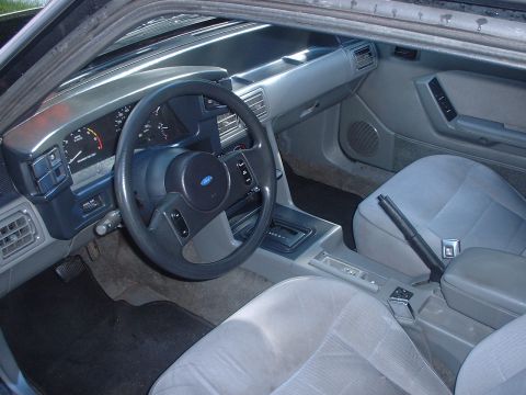 1988 Ford Mustang - Interior view of a 1988 Ford Mustang, the dashboard, steering wheel, and seats.