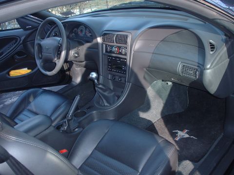 2002 Ford Mustang - The interior of a 2002 Ford Mustang features black leather seats and a manual transmission shifter.
