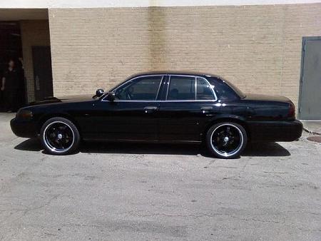 2000 Ford Crown Victoria - Side profile of a black 2000 Ford Crown Victoria with custom wheels.