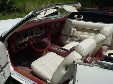 1977 Ford Mustang II - Interior view of a 1977 Ford Mustang II convertible, showing white seats and red trim.