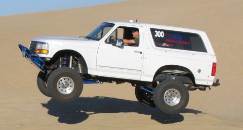 1984 Ford Bronco - This modified Ford Bronco is airborne while driving over sand dunes, its off-road capabilities.