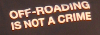 1984 Ford Bronco - Text states 'OFF-ROADING IS NOT A CRIME' in off-white capital letters against a dark background.