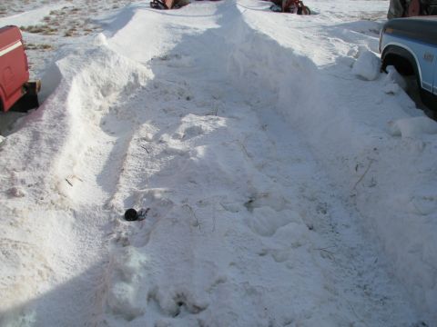 1982 Ford F-150 - Two trucks are partially visible, parked in a snowy outdoor area with a cleared path between them.