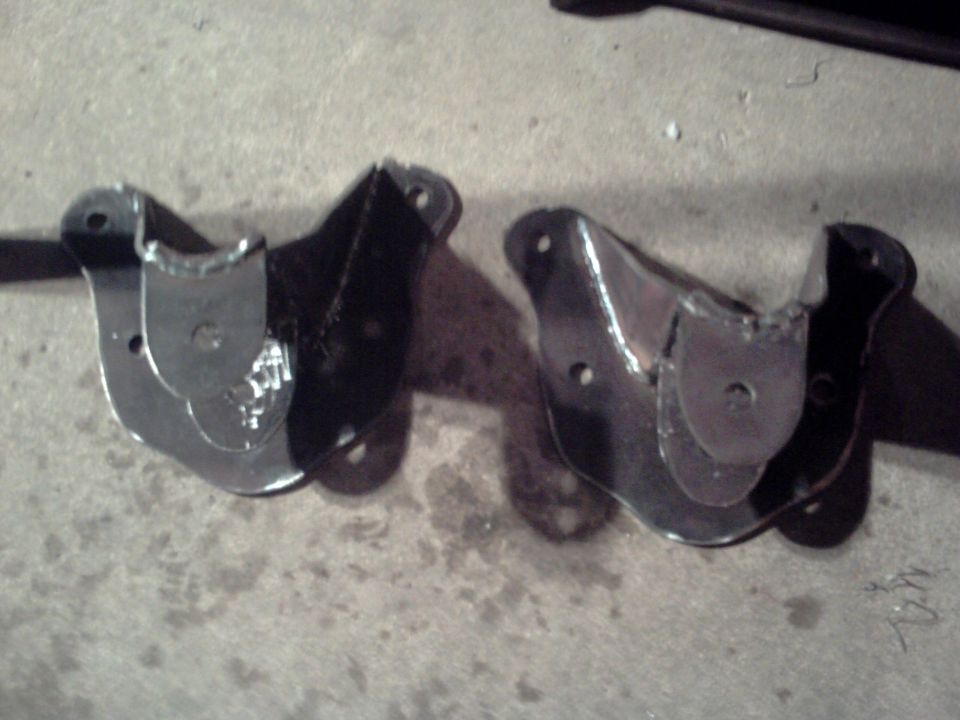 Two custom metal brackets on concrete floor