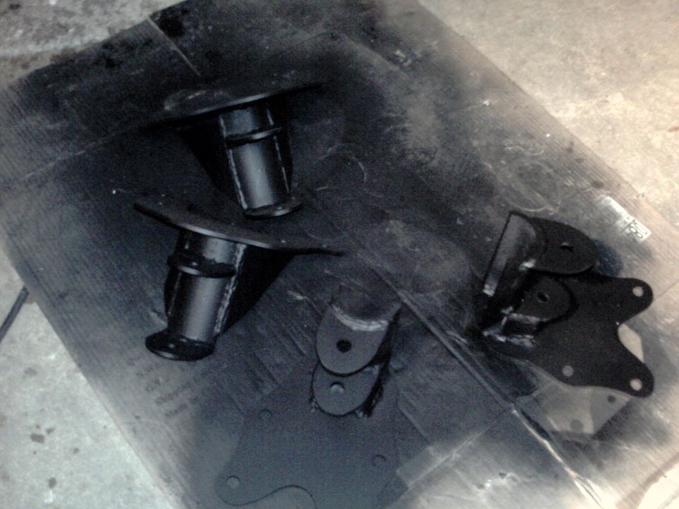 Black painted suspension components on a dark surface