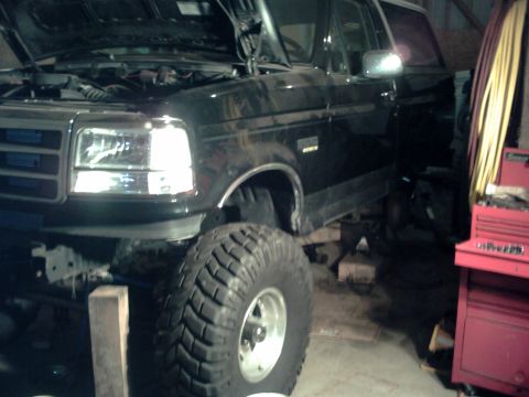 1996 Ford Bronco - This black SUV, likely from the early 1990s, is shown with its hood open and large off-road tires.