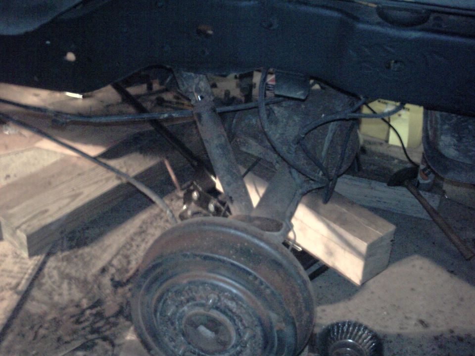 Rear axle drum brake assembly and suspension linkage, supported by wooden blocks