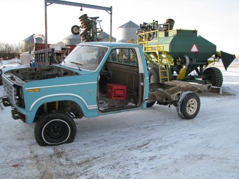 1982 Ford F-150 - This Ford F-Series truck is missing its hood and front clip, sitting on a snowy lot.