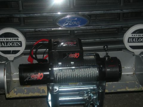1991 Ford Bronco - Front view of a 1991 Ford Bronco's grille, equipped with auxiliary lights and a winch.