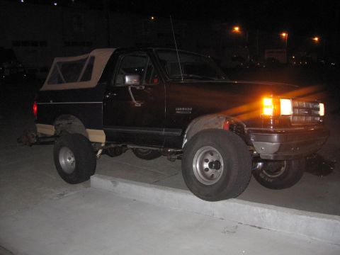 1989 Ford Bronco - This 1989 Ford Bronco features a tan soft top and is captured in a 3/4 front view.