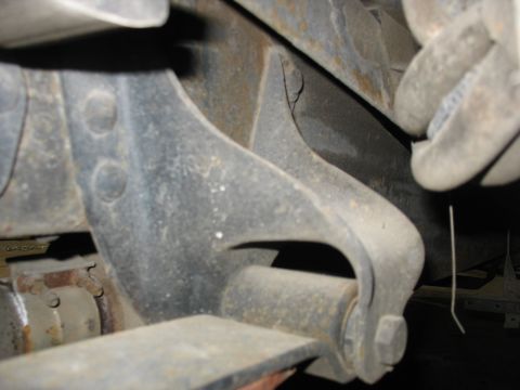 1995 Ford C-350 (Centurion Conversions) - This photo shows a close-up view of the suspension system, specifically the spring hanger and leaf spring attachment point on a vehicle.