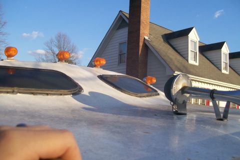 1982 Ford E350 - Close-up of a vehicle's roof, showing amber lights and a horn. The background includes a house and trees.