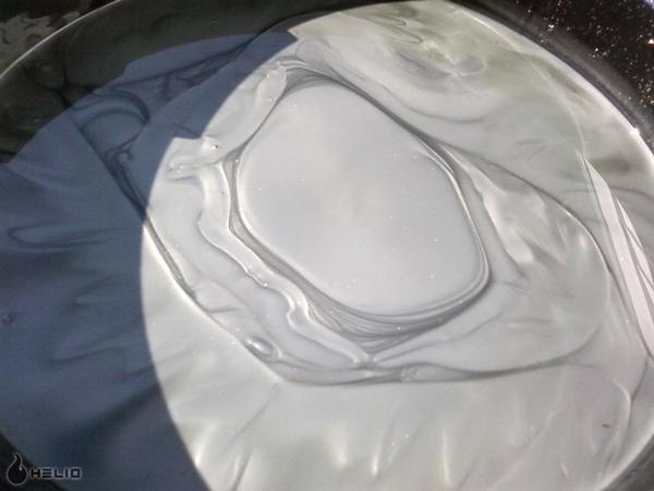 Abstract swirling white and gray liquids in a container.