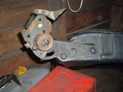 1990 Ford Ranger - A close-up view of a mechanical jack mechanism, likely for a vehicle, with visible springs and metal components attached to a black metal h…