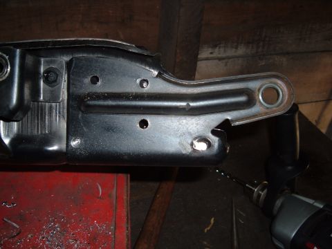 1990 Ford Ranger - A black metal bracket with several holes drilled into it is shown, with a drill bit extending from one of the holes. The bracket appears to…