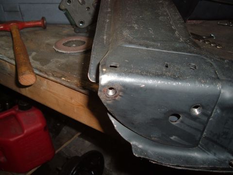 1990 Ford Ranger - A close-up view of a metal automotive part, possibly a frame or body panel, with several threaded holes visible. Tools like a hammer and a…
