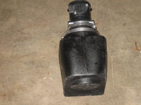 1996 Ford Thunderbird - A black aftermarket air intake system is shown resting on a concrete floor. The intake features a large black plastic housing with a metal…