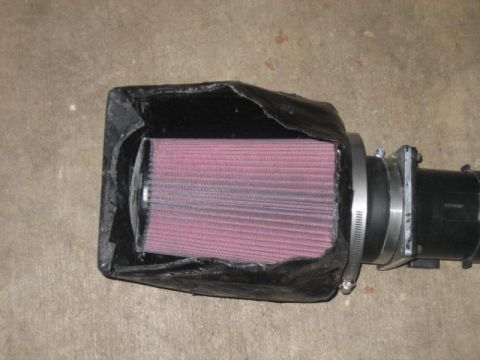 1996 Ford Thunderbird - A custom black air intake box with a pink K&N air filter is attached to a black sensor housing with a metal clamp. The air intake box appea…