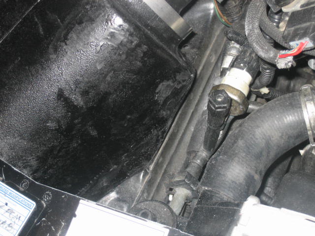 Engine bay with black hose and sensor