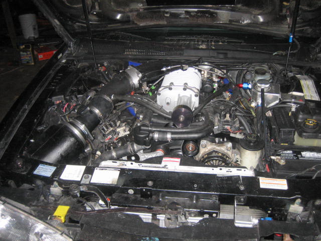 Engine bay of a 1996 Ford Thunderbird with a supercharger.