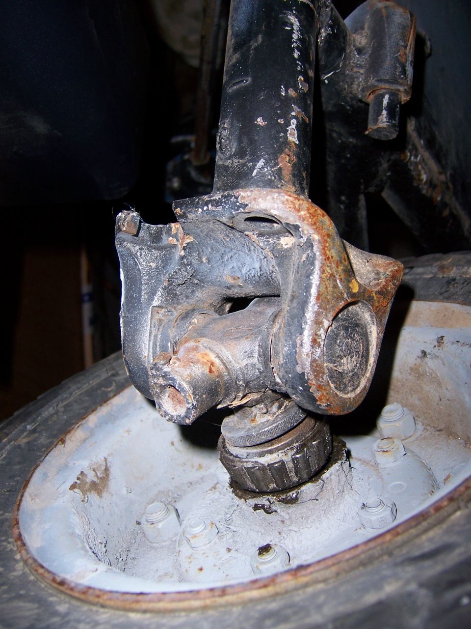 Rusty steering knuckle and spindle assembly mounted over a wheel hub
