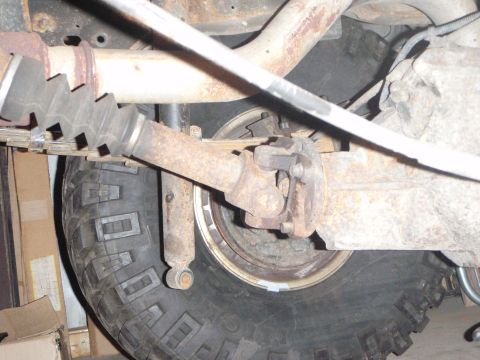 1996 Ford Bronco - A close-up view of the underside of a 1996 Ford Bronco, focusing on the rear axle, driveshaft, and a portion of the tire. The components sh…