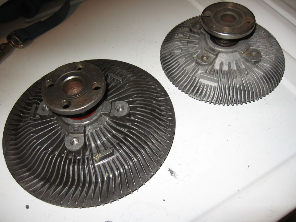 Two automotive fan clutch assemblies on a white surface.