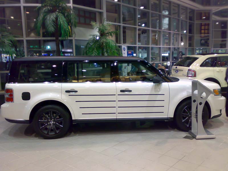 White SUV with black roof and horizontal black trim on doors. Another white SUV is parked behind it
