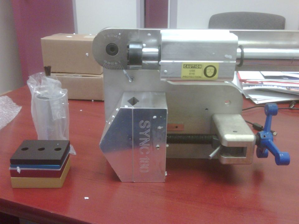 Aluminum SYNC 130 bench fixture clamped to a red table