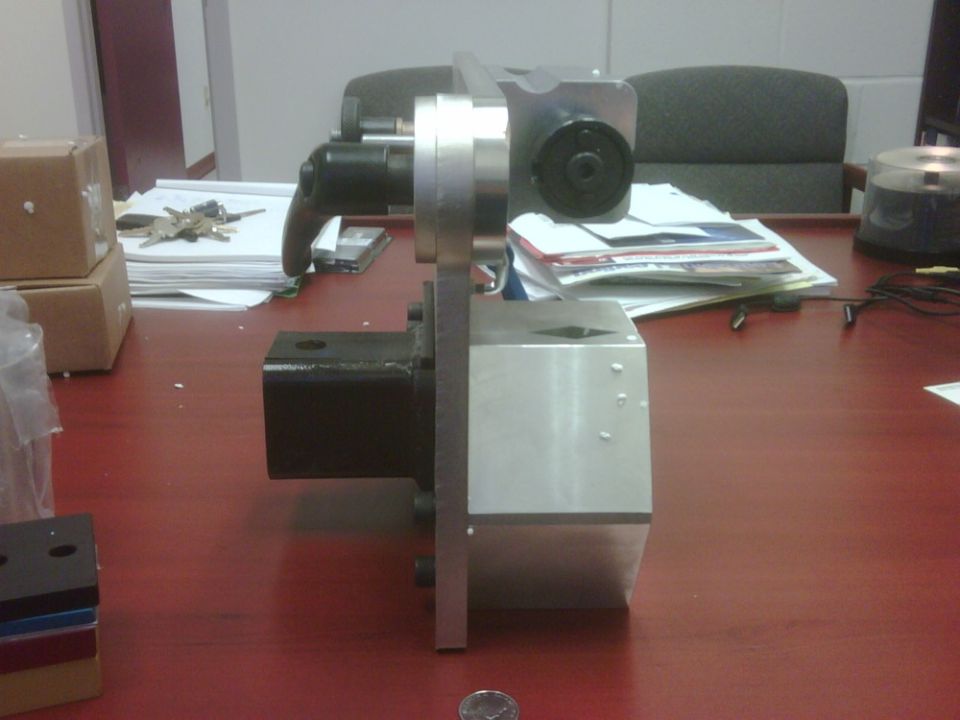Side view of a machined aluminum and steel fixture on an office table
