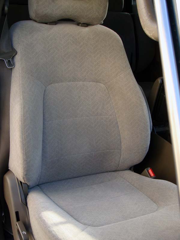 Gray cloth front bucket seat with headrest in SUV, viewed through open door