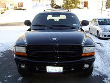 1972 Ford Ranchero - The front view of a black SUV is shown parked on a driveway with snow on the ground. The vehicle has a black grille and clear headlights.