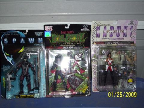 1991 Ford Bronco - Collection of three packaged action figures, including Spawn, Lady Death, and Kabuki, displayed on a shelf.