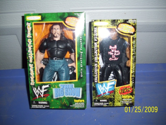 Two WWF action figures, The Big Show and The Rock, in their boxes.