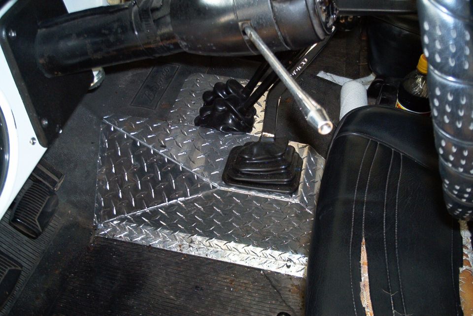 Diamond plate flooring and black vinyl seats in a vehicle interior with a floor shifter