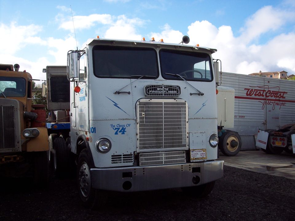 White semi-truck with "The Class of '74" decal and blue lightning bolts