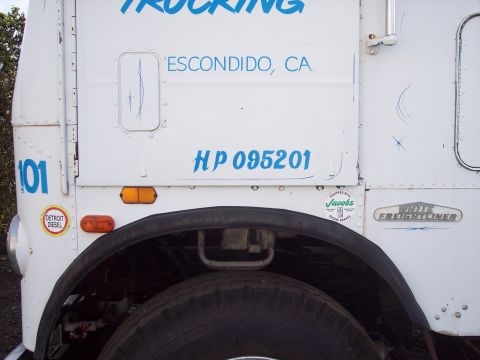 1981 Kenworth W900A - Side view of a White Freightliner truck, showing company markings and identification numbers.