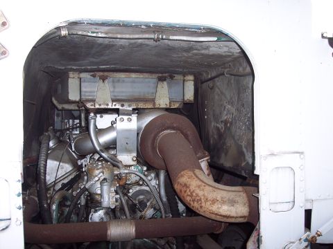 1981 Kenworth W900A - The engine compartment of a large truck, a large turbocharger and rusty exhaust pipes.