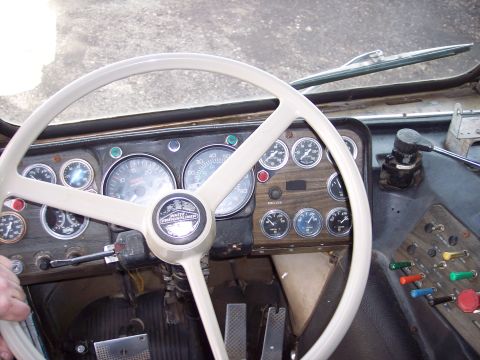 1981 Kenworth W900A - Interior view of a truck's dashboard, showing gauges and controls. A 'Freightliner' logo is visible on the steering wheel hub.