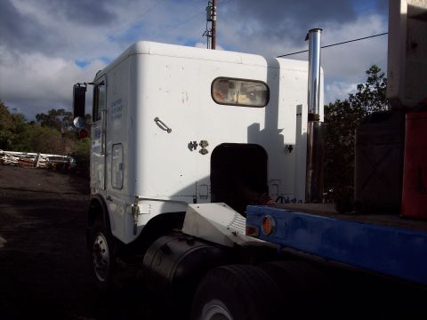 1981 Kenworth W900A - Rear 3/4 view of a white 1981 Kenworth W900A semi-truck cab. Text is visible on the driver's door.