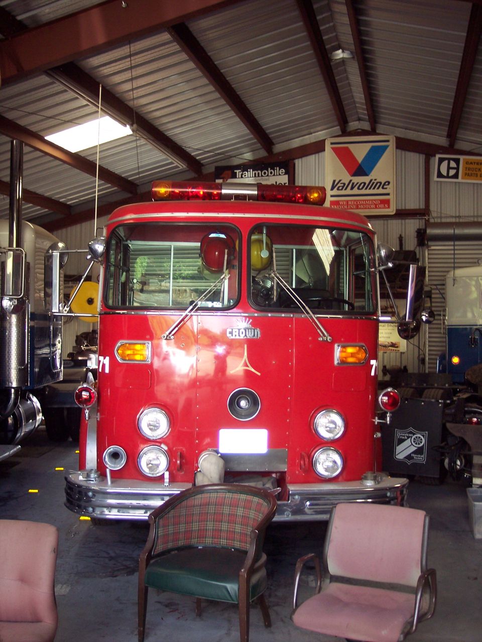 Red fire truck with chrome bumper and emergency lights. Text 'CROWN' visible on the grille