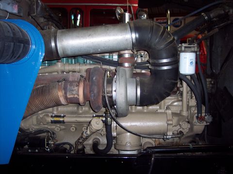1981 Kenworth W900A - Close-up view of a large diesel engine's turbocharger and associated plumbing.